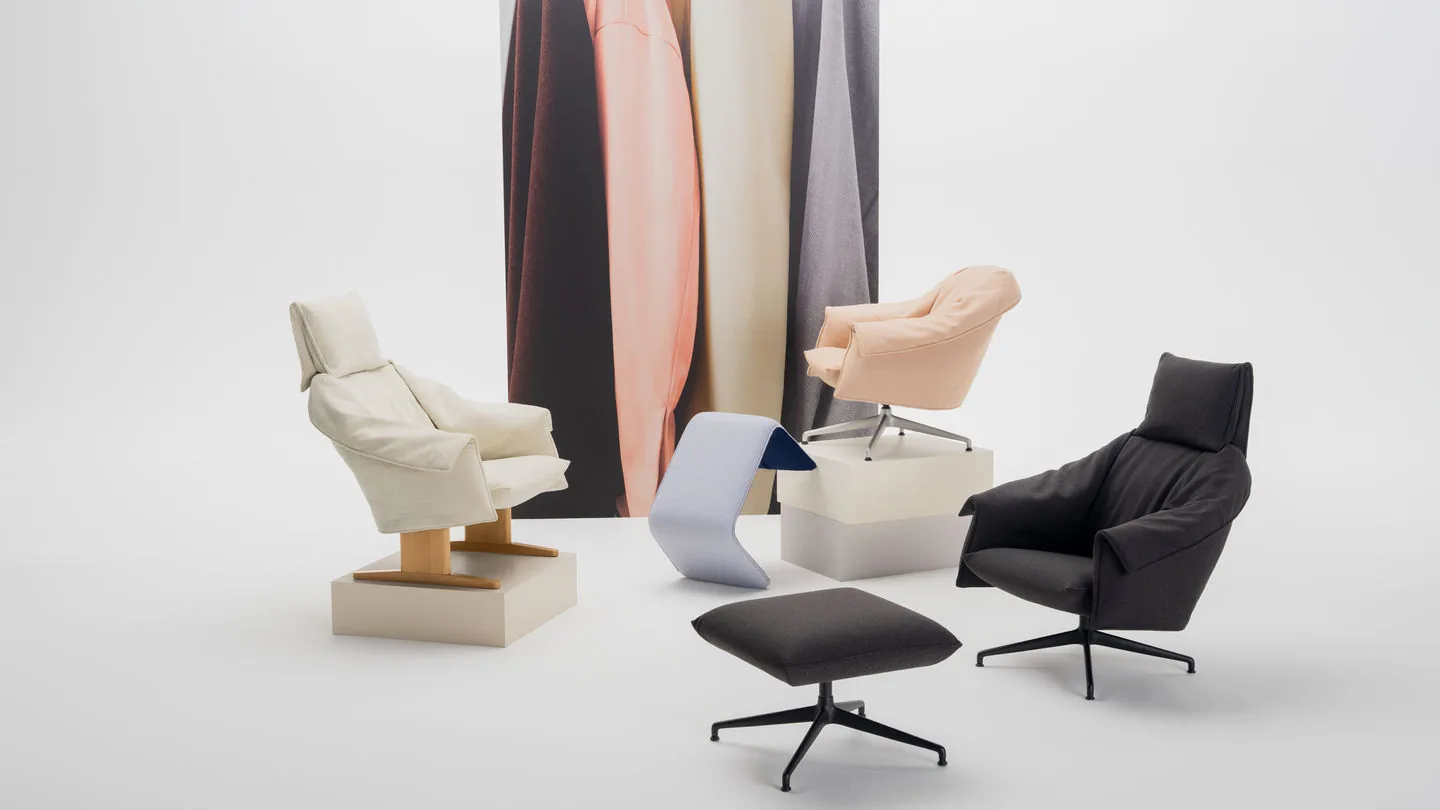 Vitra Bascule: Loungesessel und Ottomane in Creme, Pfirsich und Schwarz vor herabhängenden Stoffbahnen